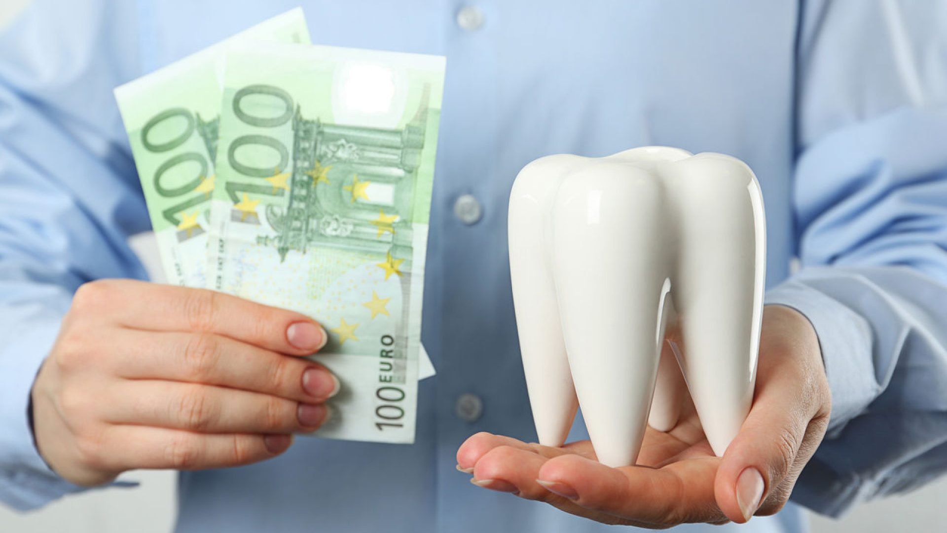 Mann hält Zahn und Geld