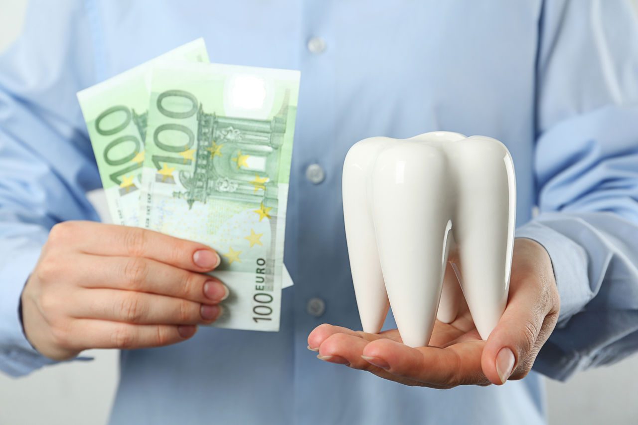 Mann hält Zahn und Geld